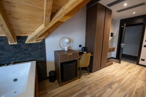 a room with a desk and a table with a mirror at PineHill Hotel, Restaurant , Pool & Spa - RAZEM in Razëm