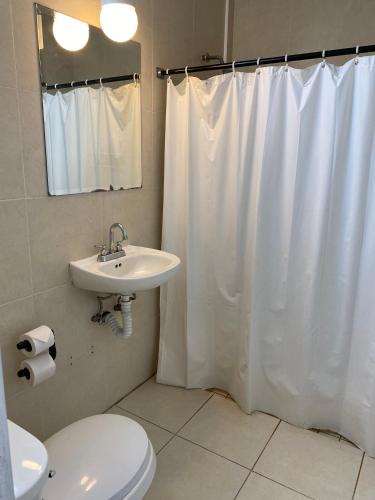 a bathroom with a white shower curtain and a sink at Hotel H Americas in Guadalajara