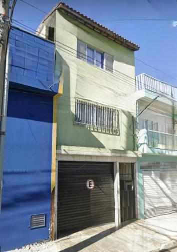 a building with two garage doors in front of it at Lindos sobrado aconchegante próximo ao aeroporto de Guarulhos Ponte Alta! in Guarulhos