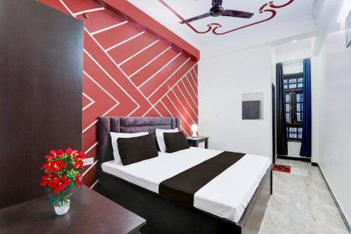 a bedroom with a bed and a red wall at OYO 83128 Kp Guest House in Bāra Banki