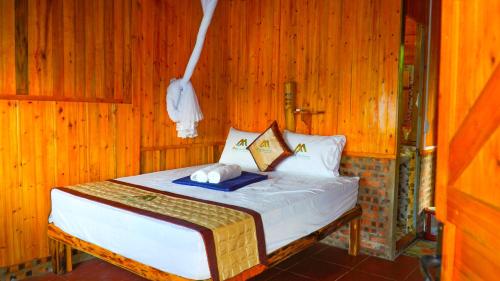 a bedroom with a bed in a wooden room at Hoàng Su Phì - Móng Ngựa Homestay in Ha Giang