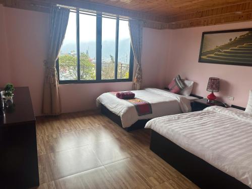 a hotel room with two beds and a window at Nhà Nghỉ Đức Anh in Sa Pa