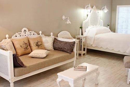 - un salon avec un canapé et un lit dans l'établissement Kastelein Guesthouse, à Pongola