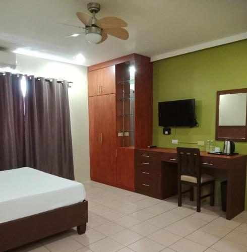 a bedroom with a bed and a desk with a television at Joyce Apartelle Mandaluyong in Manila