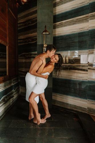 a man and woman hugging each other in a room at Maddu Suites in Ubud