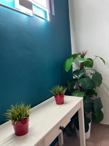 a white bench with two potted plants on it at Green Cove Villa A Famosa Karaoke Netflix Private pool in Simpang Empat