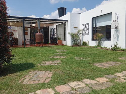 a house with a grass yard in front of it at Casa mirador al cerro del águila in Sopó
