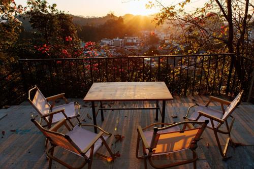 a table and chairs sitting on a deck with the sunset at BG Stone Homestay in Mộc Châu
