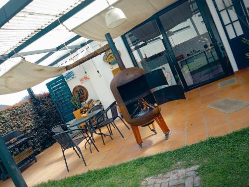 a porch with a piano and a table and chairs at Casa mirador al cerro del águila in Sopó