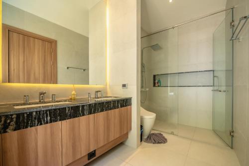 a bathroom with a sink and a toilet and a mirror at Mouana Breeze Mai Khao VIP 4-bedroom Pool Villa 9913 in Mai Khao Beach
