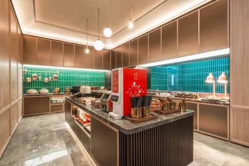 a large kitchen with a counter in a restaurant at Orange Hotel Foshan Shunde Happy Coast Scenic Area in Shunde