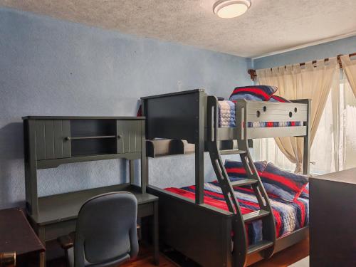 a room with two bunk beds and a desk and a chair at Departamento cerca de Reforma y Chapultepec - atrás Torre Mayor in Mexico City