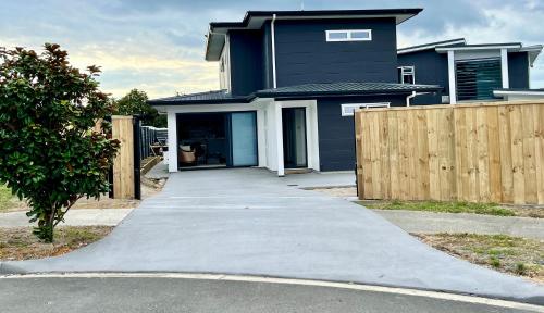 a driveway in front of a blue house at Brand new Lakeside cozy two queen rooms in Taupo