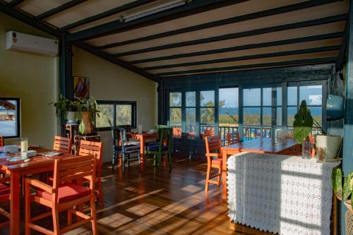a dining room with tables and chairs and windows at Hill Village Phu Yen in Phú Hiệp (2)