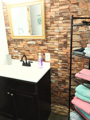 a bathroom with a sink and a brick wall at Sandy's House in Minden