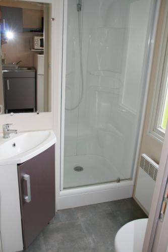 une salle de bain avec une douche avec un lavabo et des toilettes dans l'établissement Camping le Rochat Belle Isle, à Châteauroux