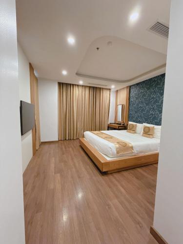 a bedroom with a large bed and a flat screen tv at Queen Hotel Hoàng Gia in Thái Nguyên