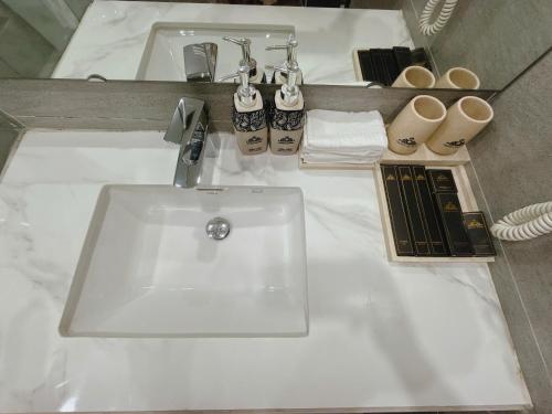a bathroom with a white sink and two mirrors at Queen Hotel Hoàng Gia in Thái Nguyên