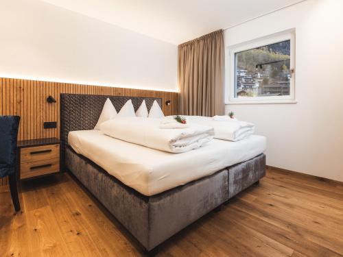 a bedroom with a large bed with white pillows at Paradeis Apartments A19 in Mühlbach