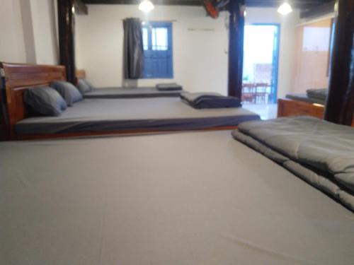 a bedroom with two beds and a window at Vũ Gia Homestay in Ấp Bình Thạnh