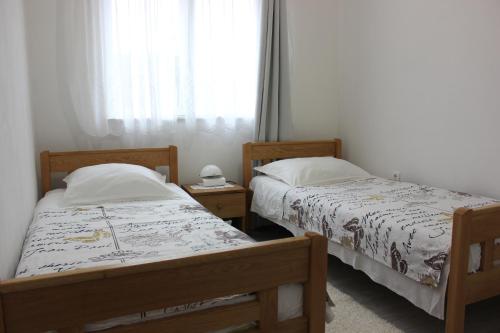 2 camas individuais num quarto com uma janela em Apartment Maras em Vodice