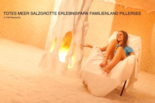 a woman sitting in a chair next to a fireplace at Ferienwohnung Alpenglück in Sankt Jakob in Haus