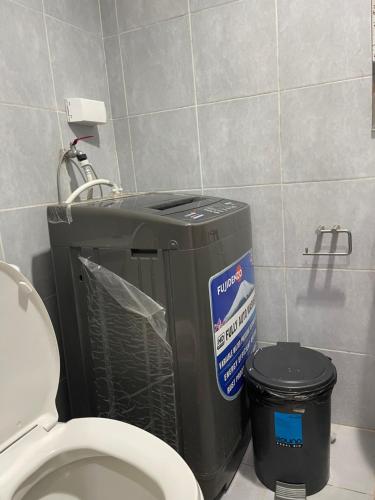 a bathroom with a toilet and a trash can at Premiere Haven MOA Staycation in Manila