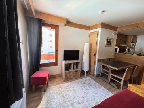 un petit salon avec une télévision et une table dans l'établissement Résidence Aconit - maeva Home - 2 Pièces 4 Personnes Sélection MAE-8881, aux Menuires