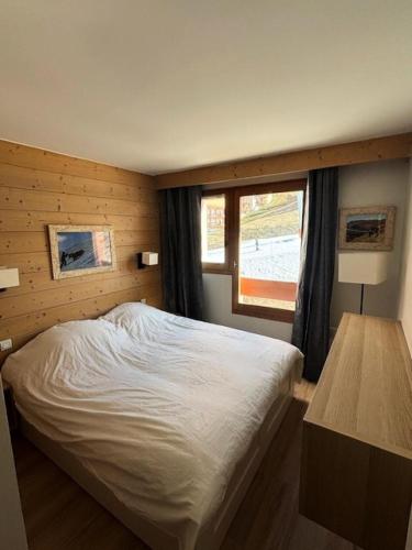 une chambre avec un lit blanc et une fenêtre dans l'établissement Résidence Aconit - maeva Home - 2 Pièces 4 Personnes Sélection MAE-8881, aux Menuires