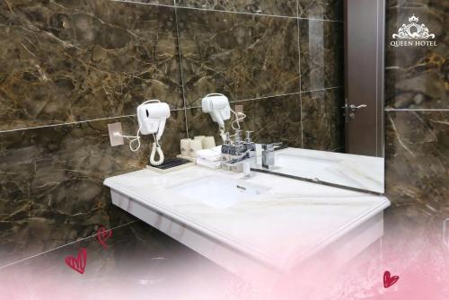 a bathroom with a white sink and a mirror at Queen Hotel Hoàng Gia in Thái Nguyên