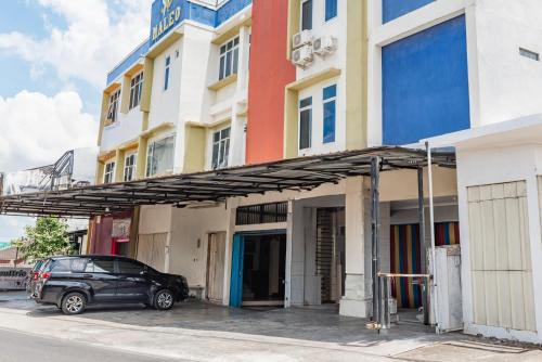 a car parked in front of a building at Hotel Maleo - 6 Hour Stay in Palembang