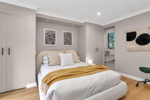 ein Schlafzimmer mit einem großen Bett mit weißen Wänden in der Unterkunft 'Parkstone' Modern Elegance near CBD & Zoo in North Adelaide