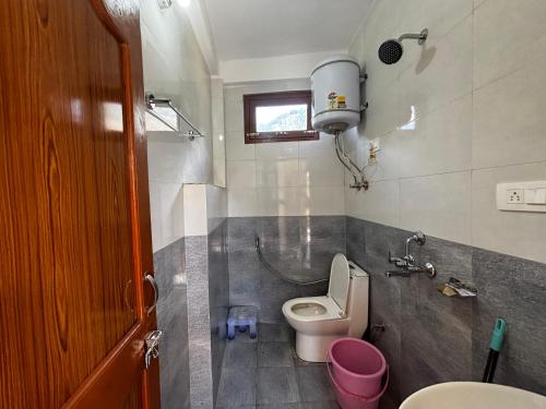 un baño con inodoro y lavabo en By The Way, en Manali