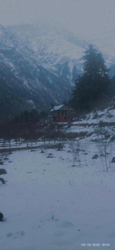 a house in a field covered in snow at MJ cafe and homestay in Kalgha