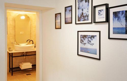 a bathroom with a sink and framed pictures on a wall at Villa Urska in Bol