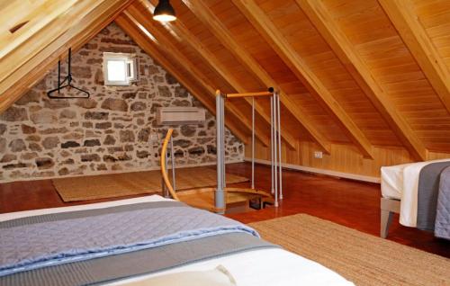 a attic room with a bed and a stone wall at Villa Urska in Bol