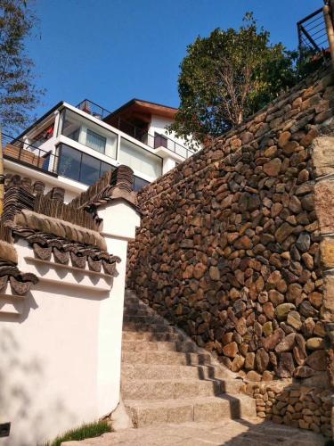 a stone wall with stairs and a building at The Western Clouds in Deqing