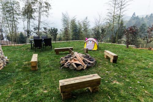 a campsite with a tent and a table and a fire at The Western Clouds in Deqing