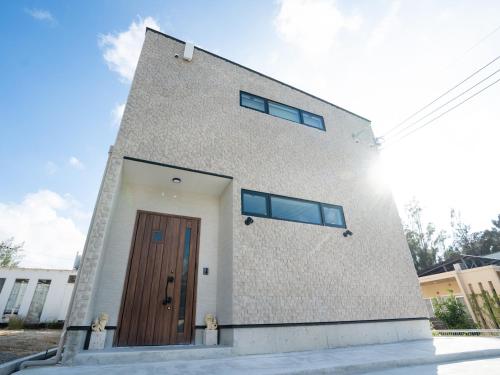a building with a door on the side of it at LikaBalli-ライカバリ- in Onna