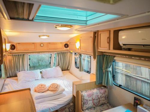 a bed in the back of an rv with two pillows at Beach House Camp in Na Jomtien