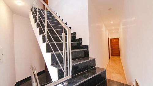 a staircase in a house with a metal railing at HOTEL AMBASSADOR SUKHNA LaKE CHANDIGARH in Chandīgarh