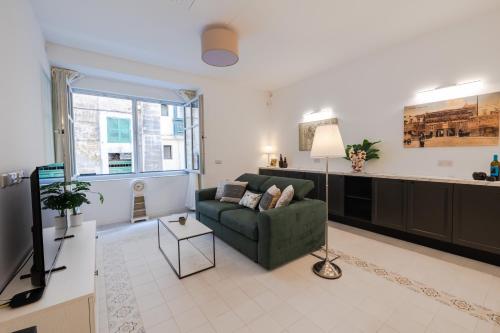 a living room with a couch and a tv at Brand New! Valletta Boutique Style Apartment in Valletta