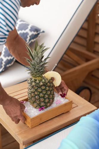 a person holding a pineapple on a cutting board at Jumeirah Emirates Towers Dubai in Dubai