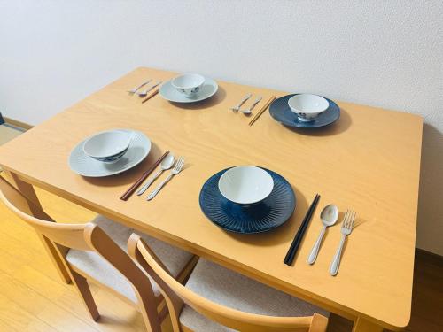 a wooden table with blue and white plates and silverware at 谷町の宿 in Osaka