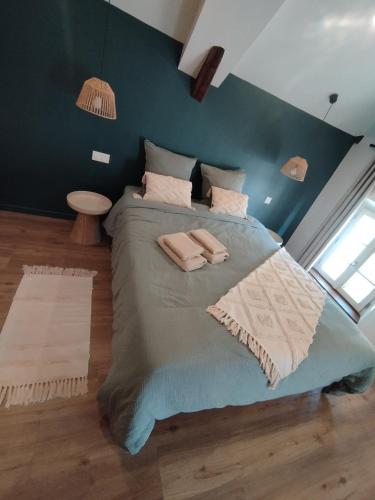 une chambre avec un grand lit avec deux serviettes dessus dans l'établissement Duplex en bord de Loire, à Saint-Martin-de-la-Place