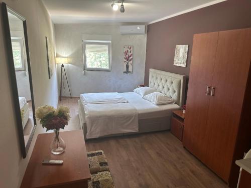 a bedroom with a white bed and a table at Apartments Bokan in Cetinje