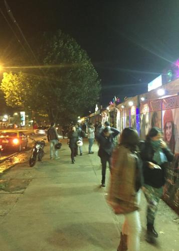 a group of people walking down a street at night at Tribu Malen Apartamentos in Temuco