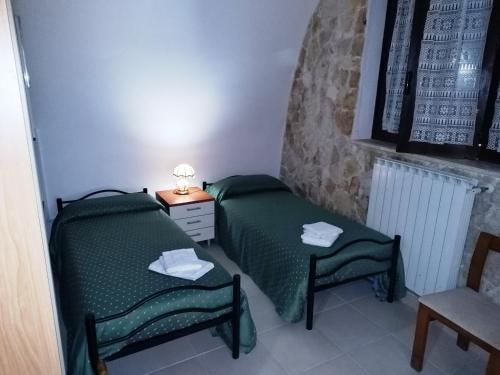 a bedroom with two green beds and a chair at Holiday Residence in Casamassima