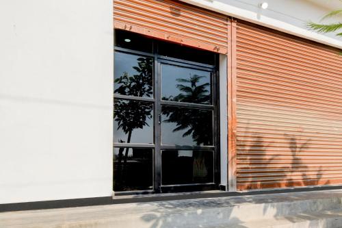 a window of a building with a reflection of a tree at Hotel O Nayati Grand in Hyderabad