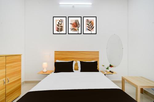 a bedroom with a white bed with a wooden headboard at Hotel O Nayati Grand in Hyderabad